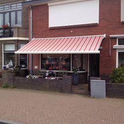 Montage van een knikarmscherm en een rolluik aan een woning aan de IJsselkade in Kampen